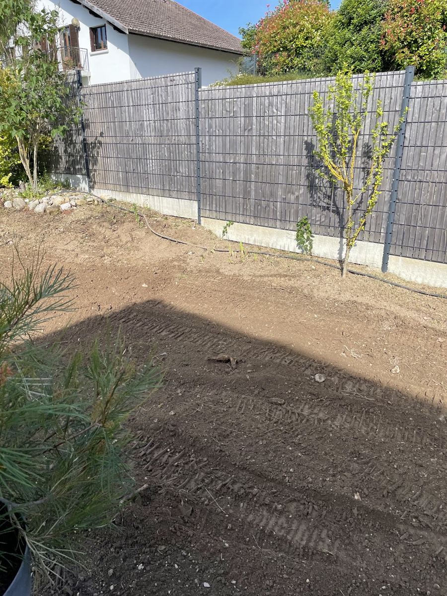 Terrain préparé et ratissé le long d'une clôture de jardin
